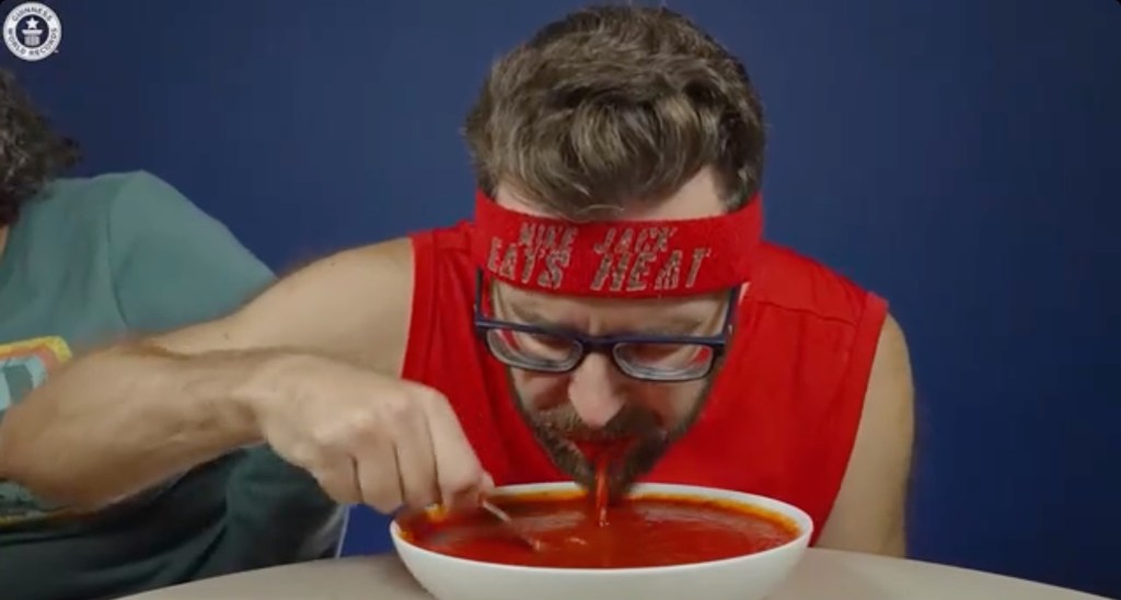 Spicy speed eater Mike Jack consumes two pounds and 7 ounces of hot sauce in three minutes, equivalent to the weight of a standard hammer.